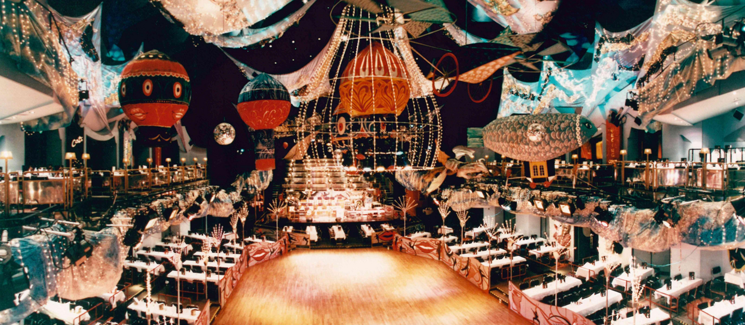 aufwendig dekorierter Theatersaal mit Ballons und weiß gedeckten Tischen