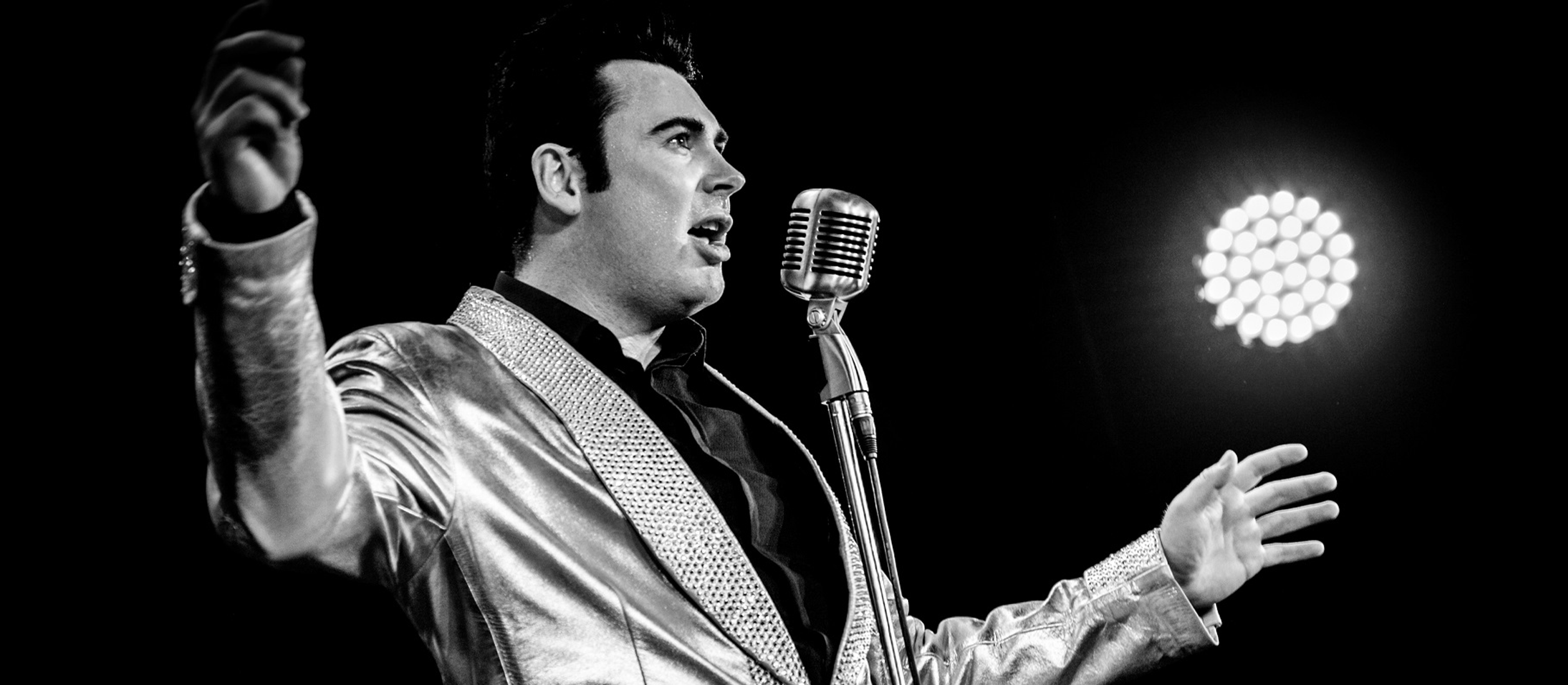 Elvis-Double Mark Summers in schwarz-weiß vor Mikrofon