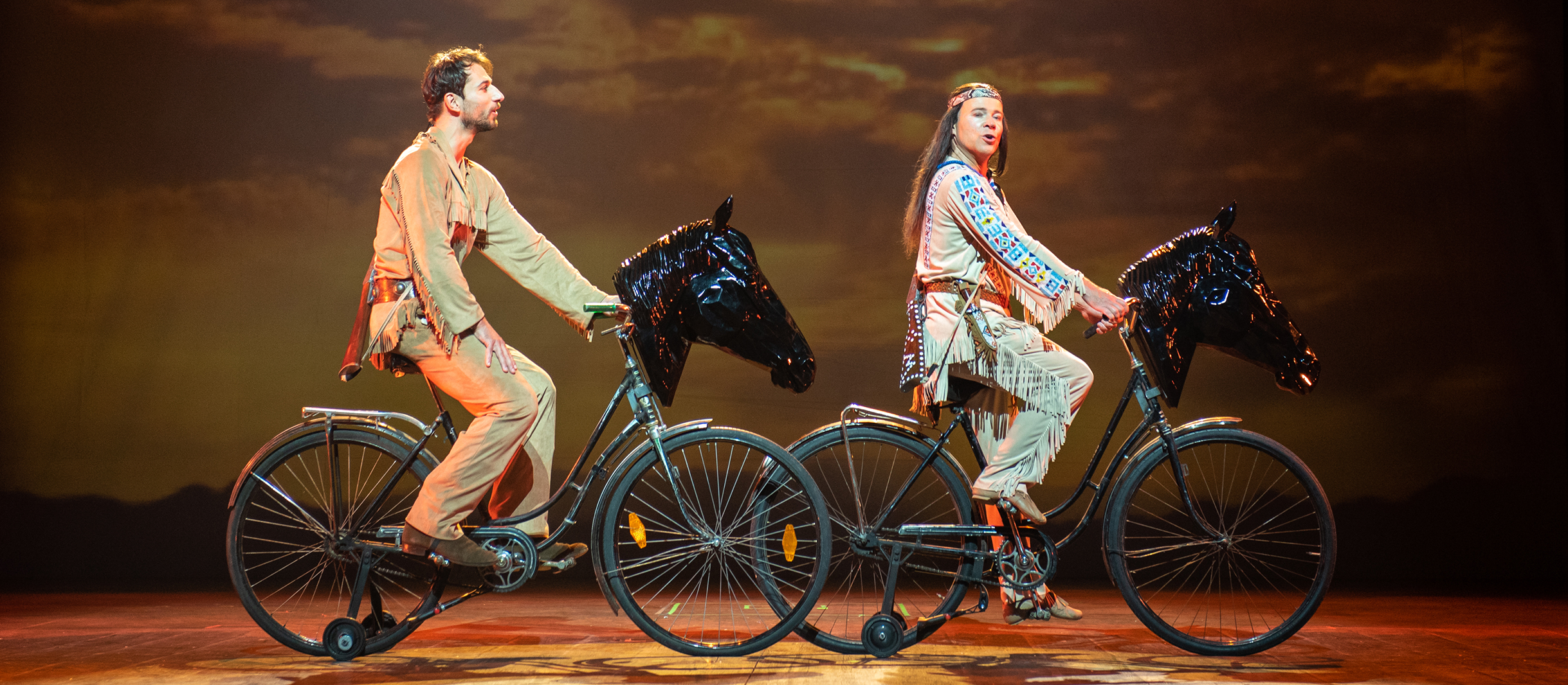 Zwei Fahrräder mit Pferdekopfauf denen Ranger und Abahachi aus dem Musical Der Schuh des Manitu sitzen